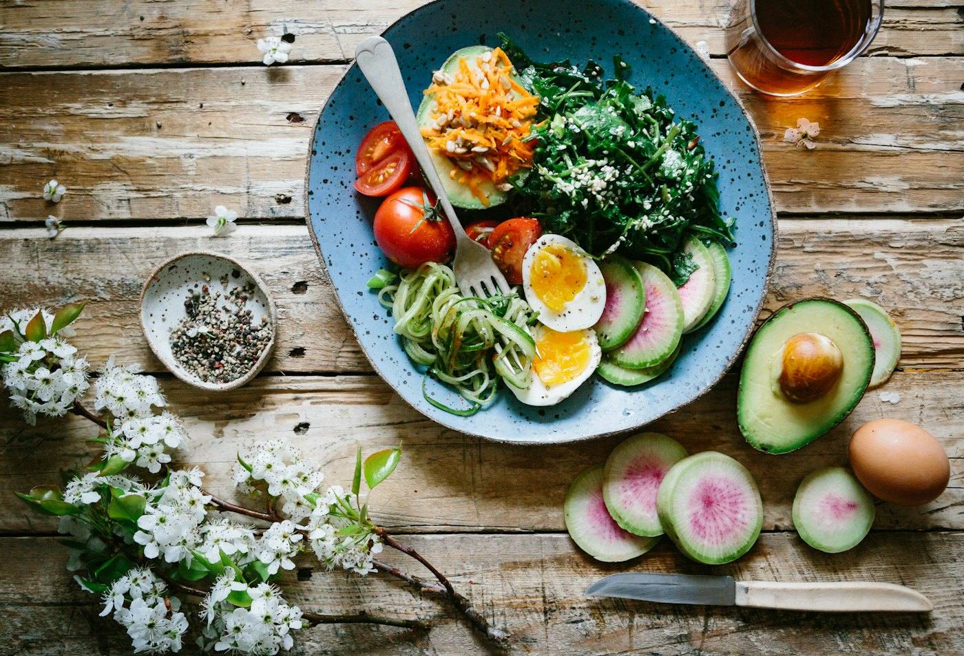 Healthy plate with eggs, greens, avocado and vegetables